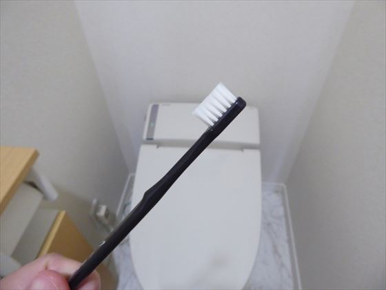 使い古した歯ブラシでトイレ掃除をするところ