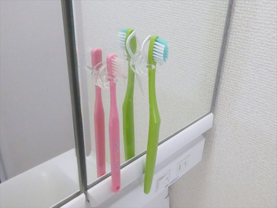 洗面台の鏡に張り付いている歯ブラシ2本
