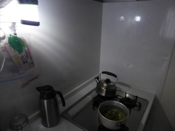 ソーラーランタンのライトで照らされているコンロ、ピーマンを蒸し煮にしている様子